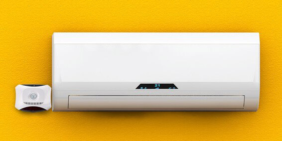 A mini split HVAC unit with EcoSense, mounted on a yellow wall.